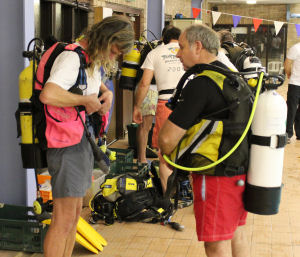 Ocean diver kitting up under the supervision of an instructor